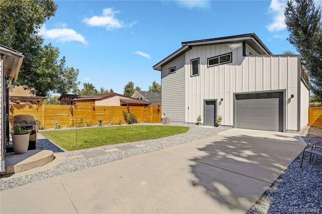 4312 Xavier St, Denver, CO 80212 - view of side of home featuring board and batten siding, concrete driveway, and a garage