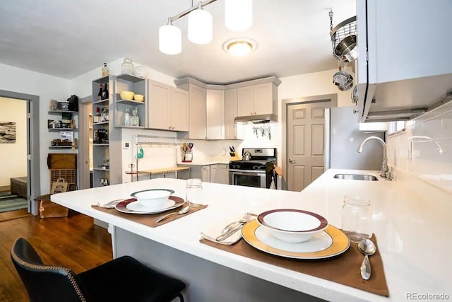 4312 Xavier St, Denver, CO 80212 - kitchen with stainless steel range with gas cooktop, a sink, a peninsula, dark wood-style flooring, and a breakfast bar area