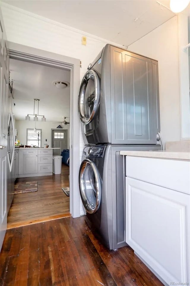 4312 Xavier St, Denver, CO 80212 - washroom with estacked washer and dryer, dark wood-style floors, and cabinet space