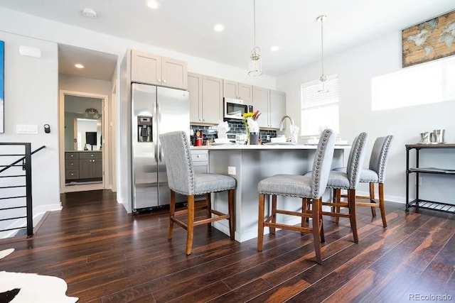 4312 Xavier St, Denver, CO 80212 - kitchen with appliances with stainless steel finishes, a kitchen breakfast bar, dark wood-type flooring, recessed lighting, and gray cabinetry