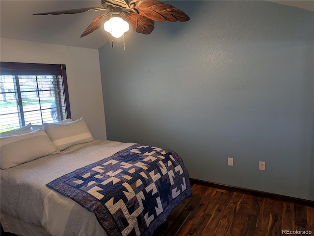bedroom featuring dark wood-style floors, a ceiling fan, and baseboards