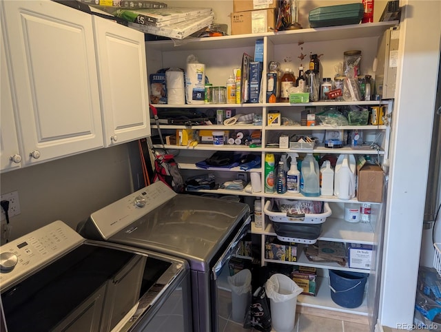 clothes washing area with independent washer and dryer, cabinet space, and tile patterned floors