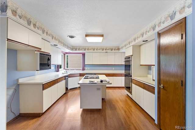 11686 W 74th Way, Arvada, CO 80005 - kitchen featuring black microwave, light wood-style flooring, white cabinets, and a textured ceiling