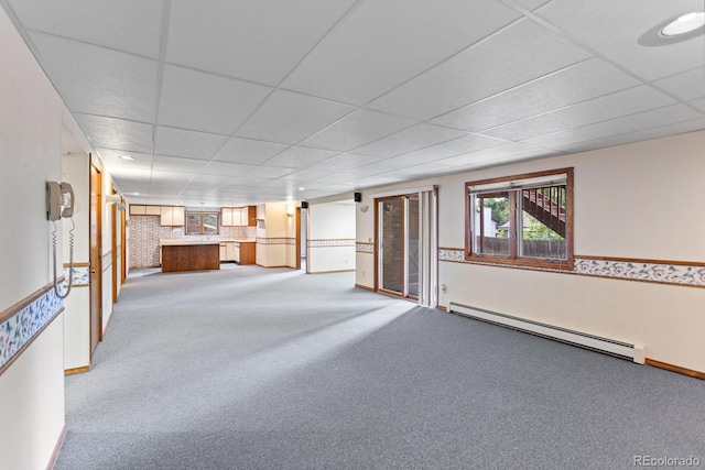 11686 W 74th Way, Arvada, CO 80005 - unfurnished living room with a baseboard heating unit, carpet floors, bar area, and a paneled ceiling