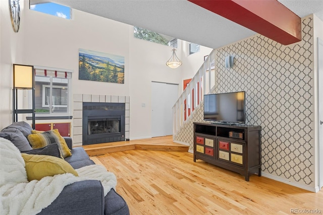 6545 W 84th Way Unit 132, Arvada, CO 80003 - living room with an accent wall, stairway, light wood-style floors, baseboards, and wallpapered walls