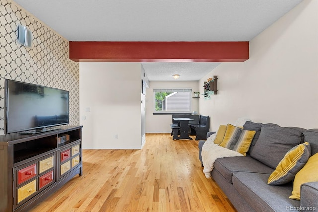 6545 W 84th Way Unit 132, Arvada, CO 80003 - living room with beam ceiling, light wood finished floors, baseboards, and an accent wall