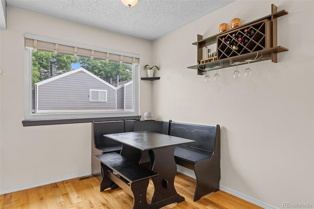 6545 W 84th Way Unit 132, Arvada, CO 80003 - dining room with wood finished floors, a textured ceiling, a dry bar, and baseboards