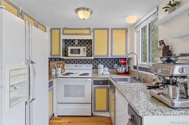 6545 W 84th Way Unit 132, Arvada, CO 80003 - kitchen with white appliances, a sink, light countertops, backsplash, and light wood-style floors