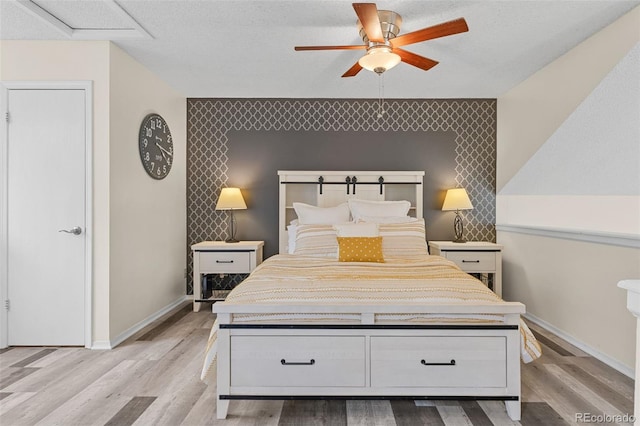 6545 W 84th Way Unit 132, Arvada, CO 80003 - bedroom featuring an accent wall, light wood-style floors, baseboards, and a ceiling fan