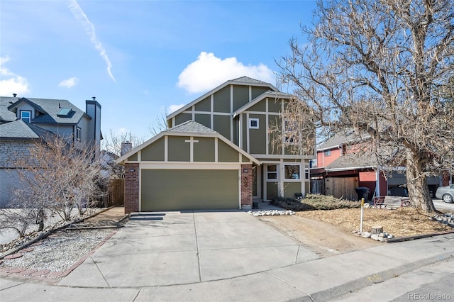 tudor house with brick siding, driveway, an attached garage, and fence