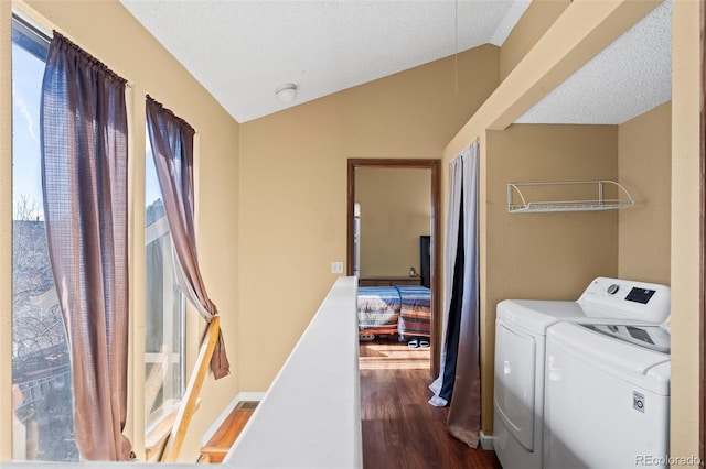 laundry area featuring laundry area, a textured ceiling, wood finished floors, and washing machine and clothes dryer