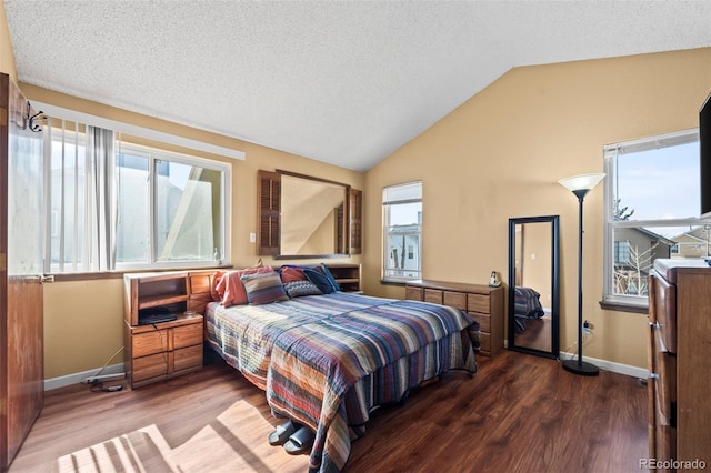 bedroom with lofted ceiling, a textured ceiling, baseboards, and wood finished floors