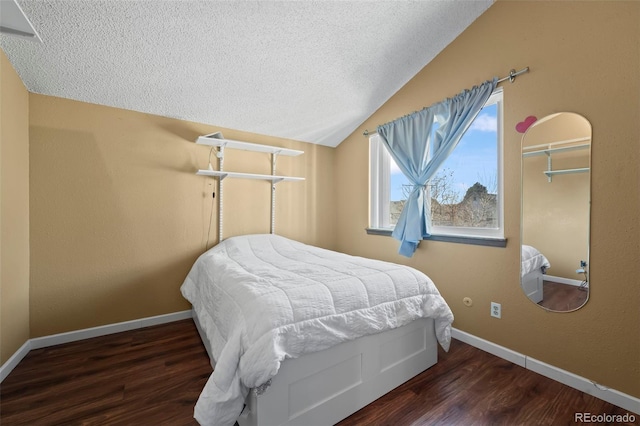 bedroom featuring lofted ceiling, baseboards, and wood finished floors