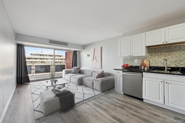 living room with baseboards, visible vents, and light wood-style floors