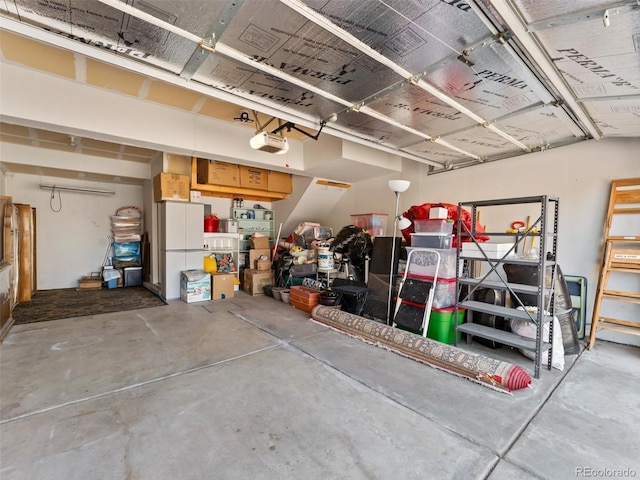 garage featuring freestanding refrigerator and a garage door opener