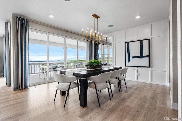 dining area with an inviting chandelier and light hardwood / wood-style floors