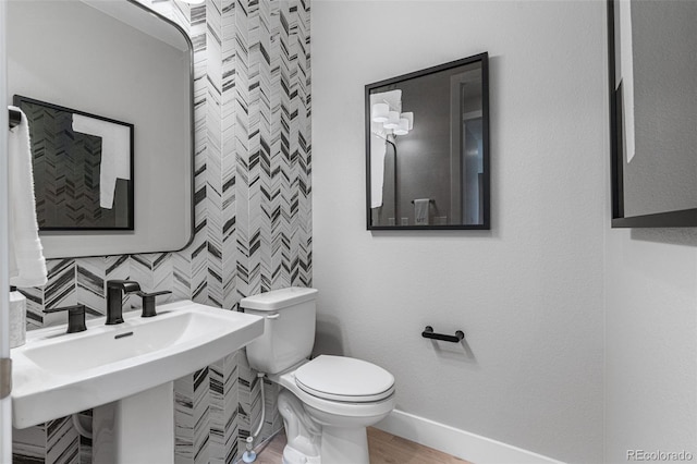 bathroom with wood-type flooring, backsplash, and toilet