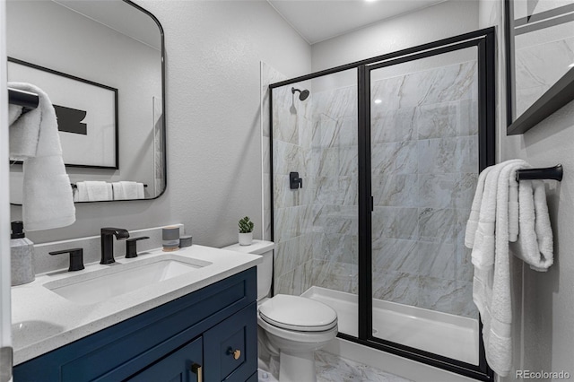 bathroom with a shower with door, vanity, and toilet