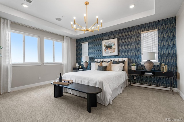 bedroom with a raised ceiling, carpet flooring, and a chandelier