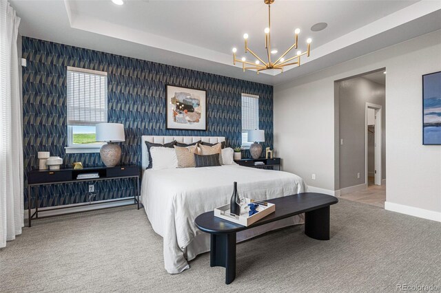 bedroom with a raised ceiling, carpet floors, and a notable chandelier