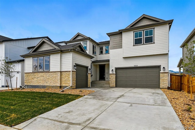 view of front of house featuring fence, a front lawn, driveway, stone siding, and a garage