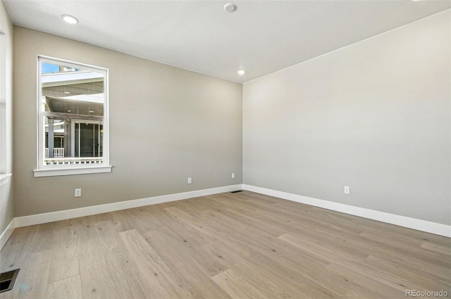 spare room featuring baseboards, visible vents, and light wood-type flooring
