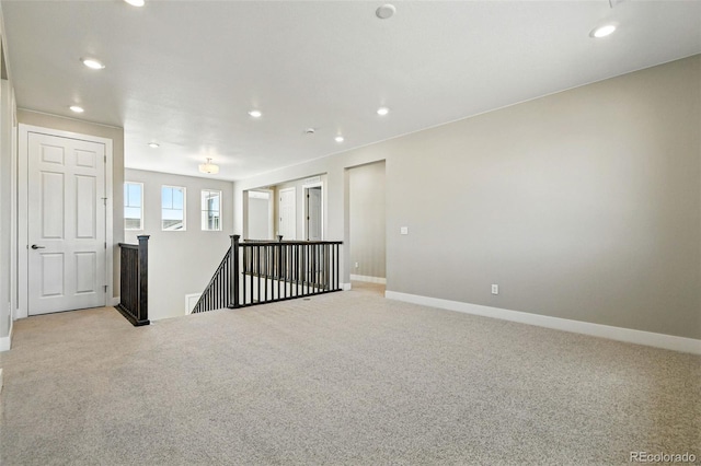 unfurnished room featuring light colored carpet, baseboards, and recessed lighting
