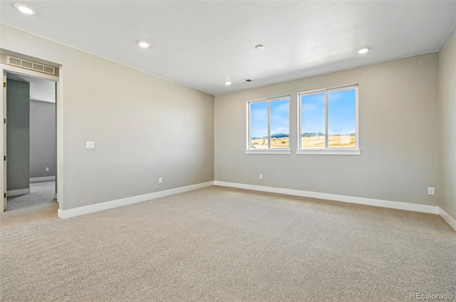 unfurnished room featuring light colored carpet, baseboards, visible vents, and recessed lighting