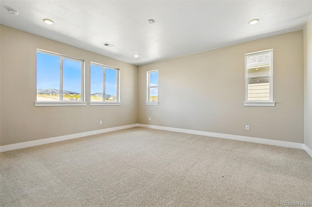 unfurnished room featuring baseboards, visible vents, recessed lighting, and light colored carpet