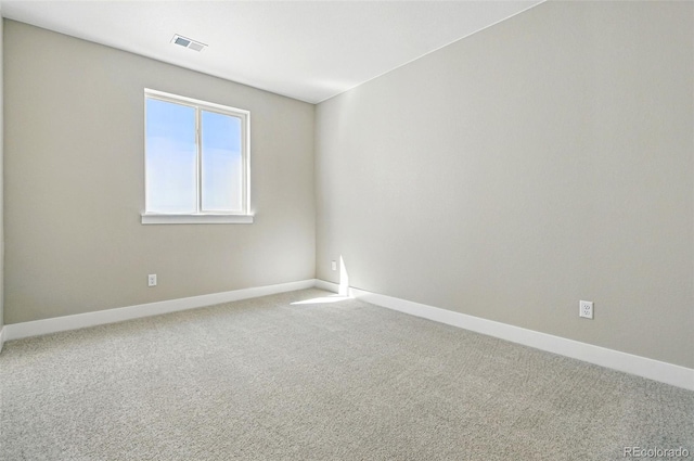 carpeted spare room with baseboards and visible vents