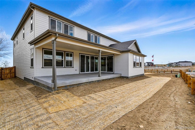 back of property with a fenced backyard and a patio
