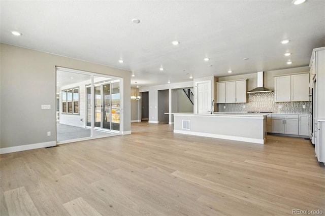 unfurnished living room featuring recessed lighting, light wood-type flooring, visible vents, and baseboards