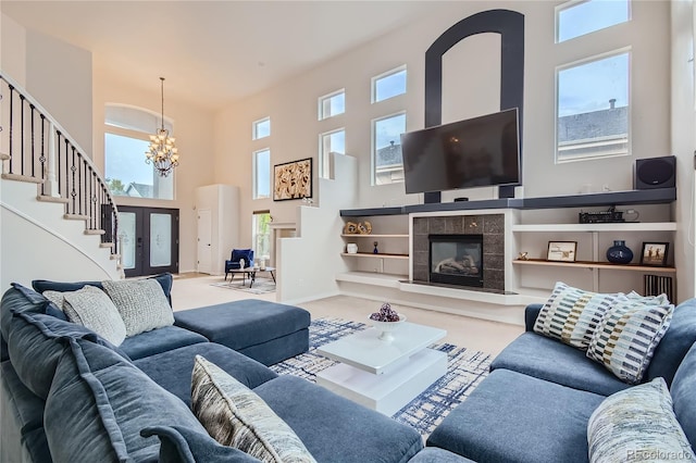 carpeted living room featuring stairs, a high ceiling, an inviting chandelier, and plenty of natural light
