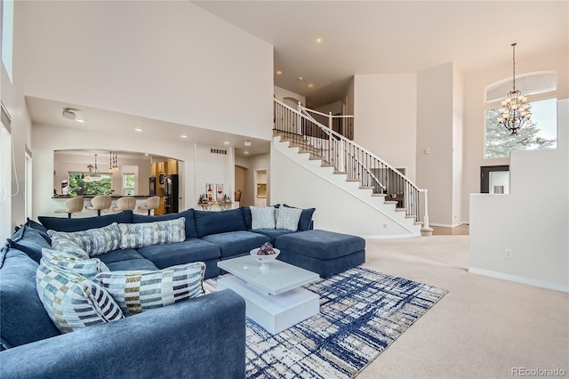 carpeted living room featuring plenty of natural light, arched walkways, a high ceiling, and stairway