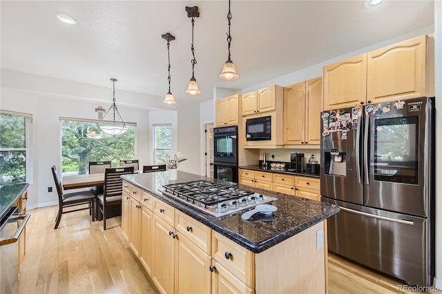 kitchen featuring a healthy amount of sunlight, light brown cabinetry, black appliances, and light wood-type flooring