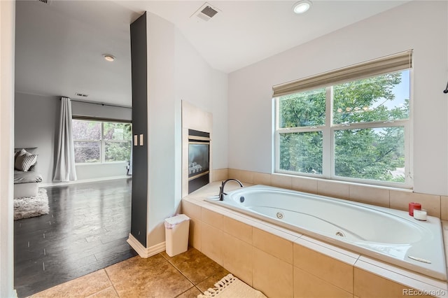 full bathroom featuring visible vents, baseboards, tile patterned flooring, and a tub with jets