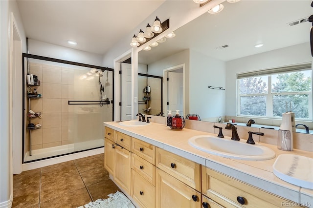 bathroom with double vanity, a sink, tile patterned floors, and a shower stall
