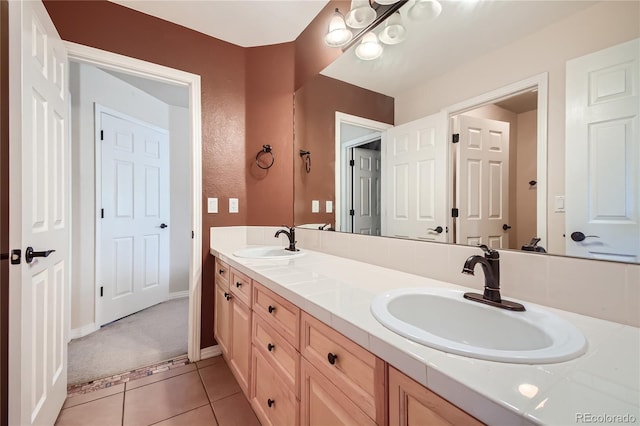full bath with double vanity, a sink, baseboards, and tile patterned floors