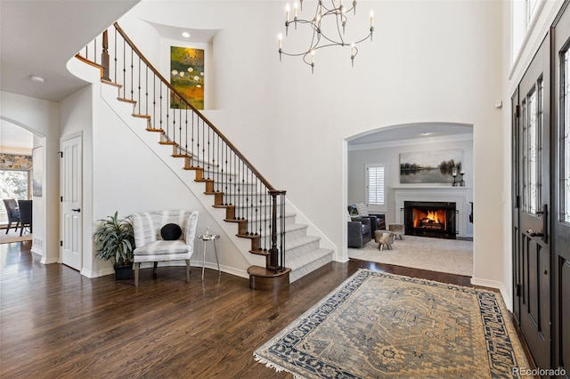 entrance foyer with a high ceiling, a chandelier, and dark hardwood / wood-style flooring