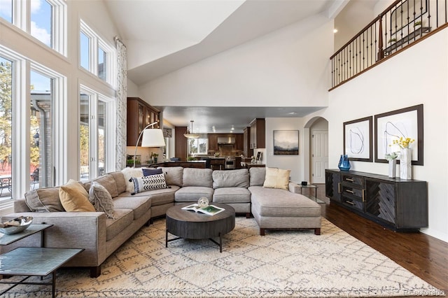 living room featuring a towering ceiling and light hardwood / wood-style flooring