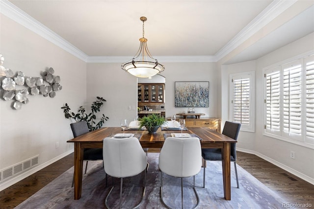 dining area with dark wood-type flooring and ornamental molding