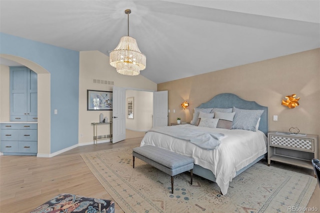 bedroom featuring a notable chandelier, vaulted ceiling, and light hardwood / wood-style floors