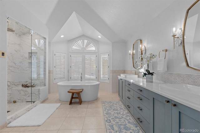 bathroom with vaulted ceiling, tile walls, vanity, independent shower and bath, and tile patterned flooring