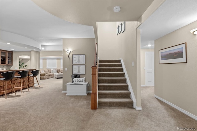 stairway featuring carpet and bar area