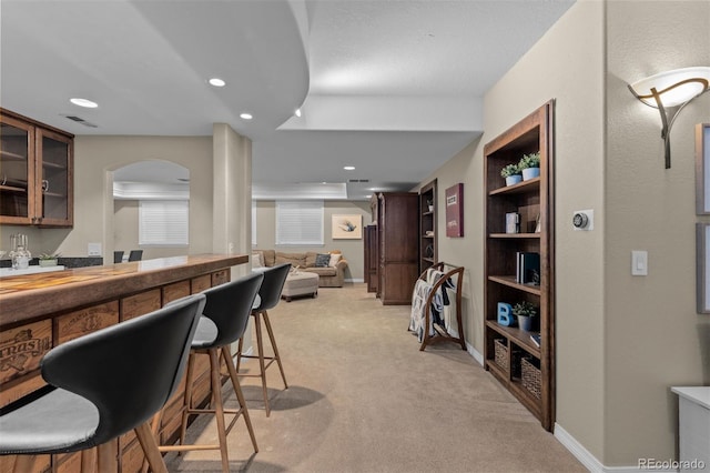 bar with built in shelves and light colored carpet