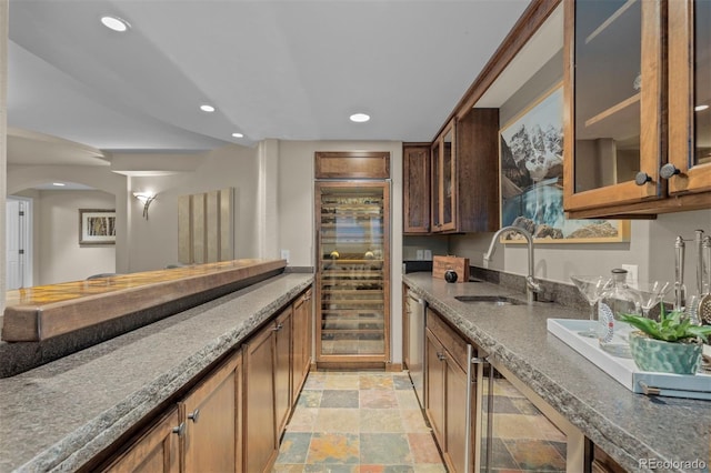 kitchen with sink, beverage cooler, dishwasher, and stone counters