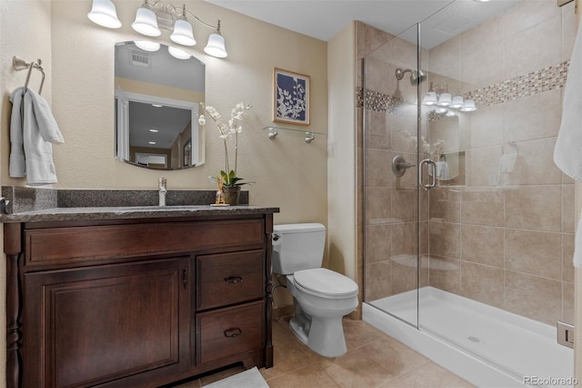 bathroom with vanity, tile patterned flooring, a shower with shower door, and toilet