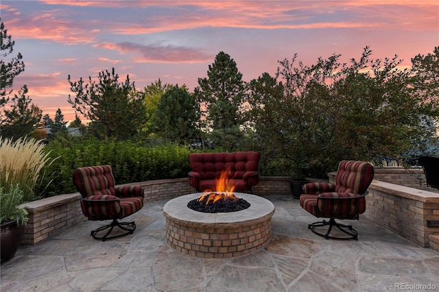 patio terrace at dusk featuring an outdoor fire pit