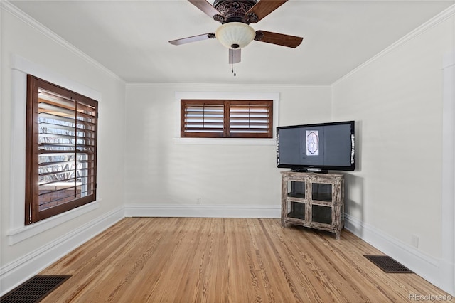 unfurnished living room with visible vents, baseboards, wood finished floors, and crown molding