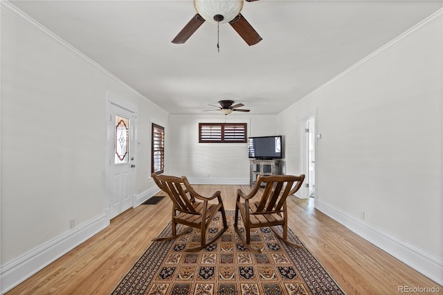 dining area featuring crown molding, light wood-style flooring, baseboards, and ceiling fan